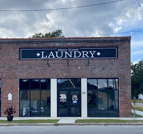 Main Street Laundry storefront at 502 Main Street in Maysville, NC — a red brick building with the painted Main Street Laundry sign above glass double doors