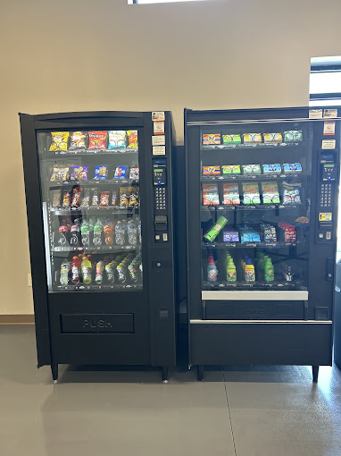 Vending machines stocked with snacks and cold drinks inside the laundromat